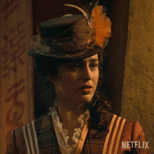 a woman wearing a hat with a feather on it and a netflix logo in the corner