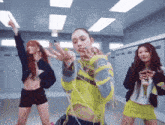 a group of young women are dancing in a room with lockers