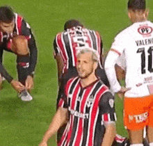 a group of soccer players are standing on a field and one of them is wearing a number 10 jersey .