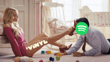 a man is petting a woman 's leg with a green spotify logo behind him