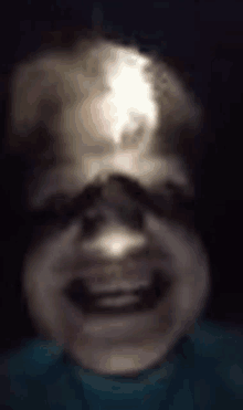 a blurry picture of a person 's face with a light shining on it .