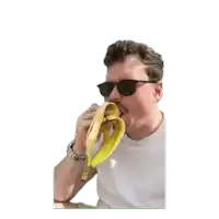 a man wearing sunglasses is eating a banana peel