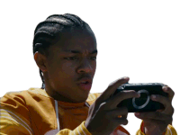 a young man in a yellow sweatshirt is playing a video game