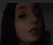 a close up of a woman 's face in a dark room .