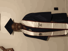 a man wearing a graduation cap and gown with class of 2021 embroidered on it