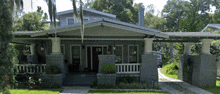 the front of a house with a porch and a white railing