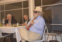 a man in a hat is playing a guitar