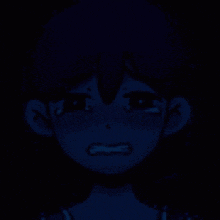 a close up of a girl 's face in the dark with tears coming out of her eyes .