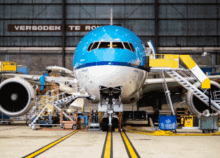 a blue and white airplane is being worked on in a hangar with a sign that says verboden te ro