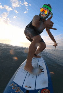 a man riding a surfboard with a santa cruz sticker