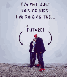 a man and a child standing in front of a wall that says i 'm not just raising kids