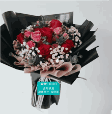 a bouquet of red and pink roses wrapped in black paper with a label that says ' pretty night ' on it