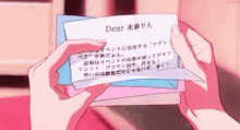 a person is holding a piece of paper that says `` dear '' .