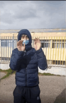 a man wearing a mask and a blue jacket is making a funny face