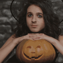 a woman in a witch hat holds a carved pumpkin with the words wishing you spooky acular halloween written above her