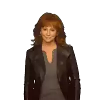 a woman with red hair is wearing a black jacket