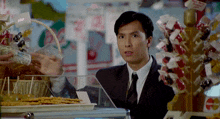 a man in a suit and tie is standing in front of a display case with a sign that says coca cola on it