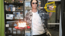 a man holding a sword and a cake with candles