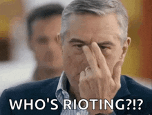 a man is holding his finger to his nose and says `` who 's rioting ? ''