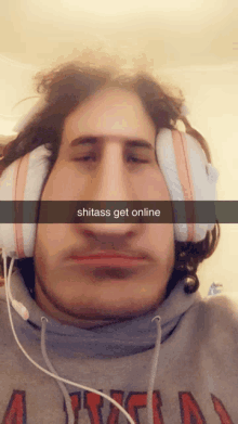 a man wearing headphones and a sweatshirt that says ' shitass get online '