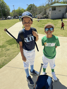 a boy wearing a green shirt that says ' shtmnm ' stands next to another boy