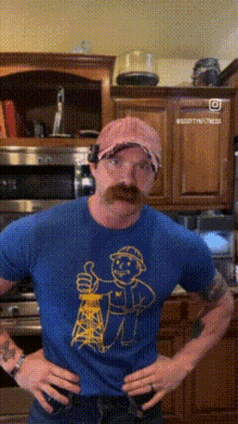 a man with a mustache is wearing a blue shirt with a picture of a man holding an oil rig on it