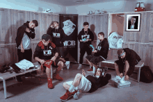 a group of young men are in a locker room wearing mob sweatshirts