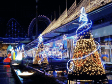 a christmas tree is lit up in front of a rollercoaster