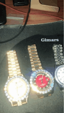 two gimars watches sit on a desk next to a computer mouse