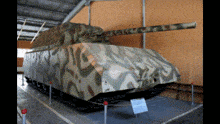 a large tank with a camouflage pattern on it is on display