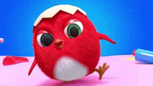 a red cartoon bird is standing on a pink table .