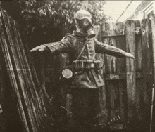 a man wearing a gas mask is standing in front of a wooden fence