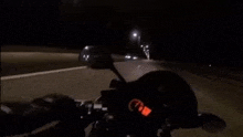 a man is riding a motorcycle down a highway at night .