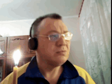 a man wearing glasses and headphones looks at the camera