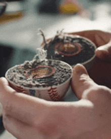 a person is holding two bowls of food in their hands