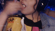 a close up of a person eating a bag of chips that says uap