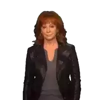 a woman with red hair is wearing a black jacket