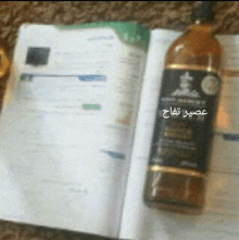 a bottle of alcohol sits on top of a book