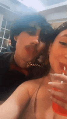 a man and a woman are taking a selfie with a straw in their mouth .