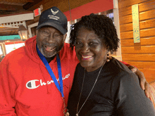 a man wearing a hat that says u.s. air force veteran poses with a woman wearing a champion sweatshirt