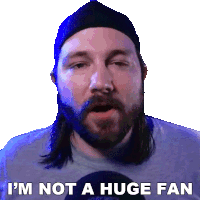 a man with long hair and a beard says " i 'm not a huge fan " in front of a white background