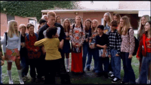 a group of people standing in front of a building with a sign on it that says ' a '