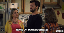 a netflix advertisement shows a man and two women in a kitchen and says " none of your business "