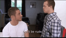 a man in a plaid shirt says " don 't be rude " to another man in a white shirt