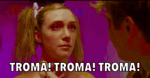 a woman with pigtails is looking at a man with the words troma troma troma