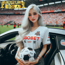 a woman holding a soccer ball wearing a shirt that says ' sbobet ' on it