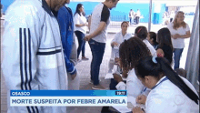 a group of people are gathered in front of a sign that says ' morte suspeita por febre amarela ' on it