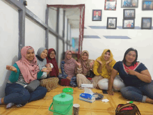 a group of women are sitting on the floor in a room