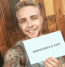 a man holds up a piece of paper that says " aminacama in chate "