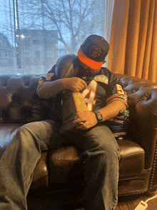 a man sitting on a couch wearing a bears jersey